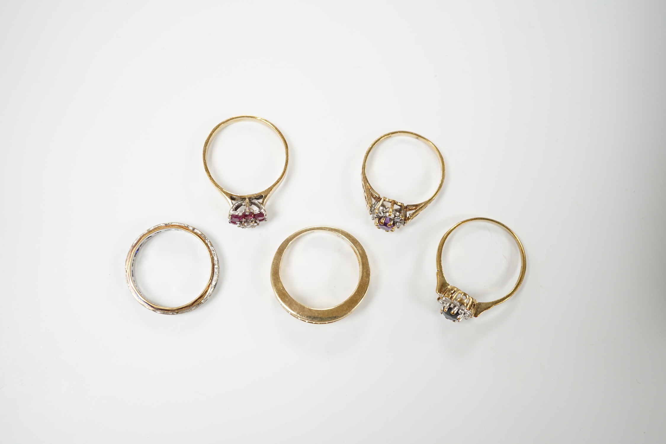 Five assorted modern 9ct gold and gem set dress rings including ruby and diamond cluster and six stone diamond set half hoop, gross weight 14.4 grams.